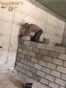 בניית קיר בלוקים עם רצועות בטון בהפרדה לחנייה. צילום: שי