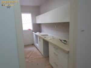 הדבקת קרמיקה בקירות במטבח בתהליך שיפוץ לדירה